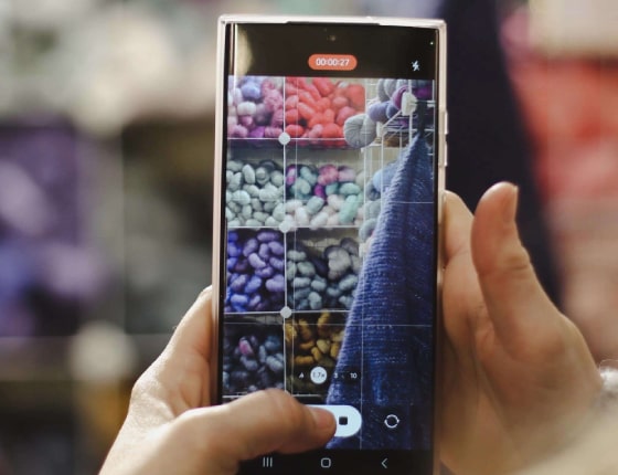 Téléphone prenant en photo un stand de pelotes de laine sur le salon Créations & savoir-faire