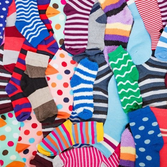 Ensemble de chaussettes colorées aux motifs variés étalées sur une surface.
