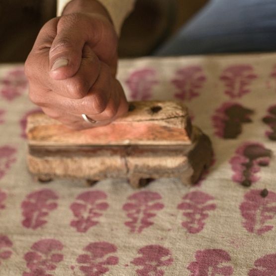 Impression textile manuelle avec tampon en bois sur tissu motif floral.