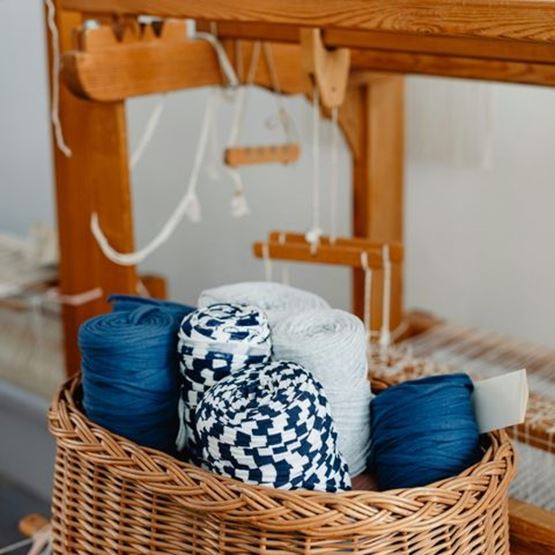 Grosse bobine de fil et filet, illustrant les usages textiles du tissage.