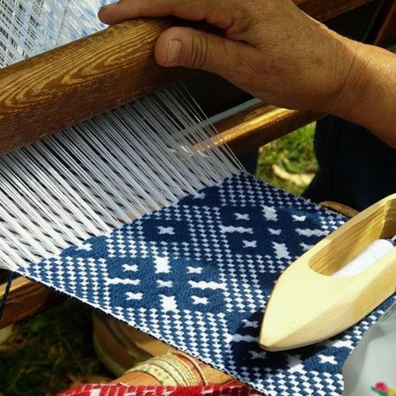 Conseils de tissage avec outils et fils colorés sur une table en bois.