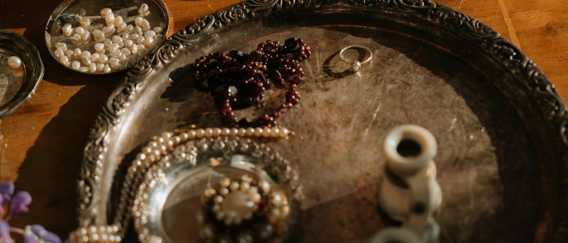 Perles blanches et rouges disposées sur un plateau ancien pour le tissage.