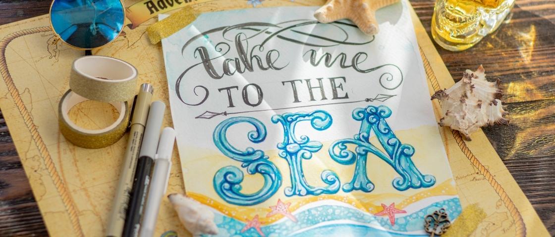 Illustration colorée de lettering "Take me to the sea" entourée de coquillages et stylos.