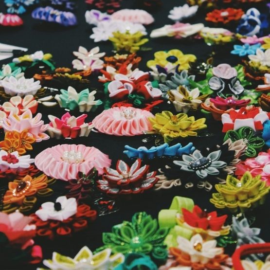 Collection de fleurs artisanales en tissu coloré ornées de perles et détails décoratifs