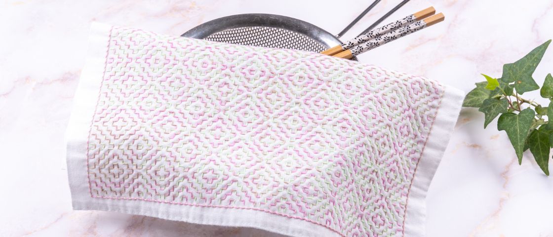 Mains cousant du tissu noir avec outils de couture en arrière-plan