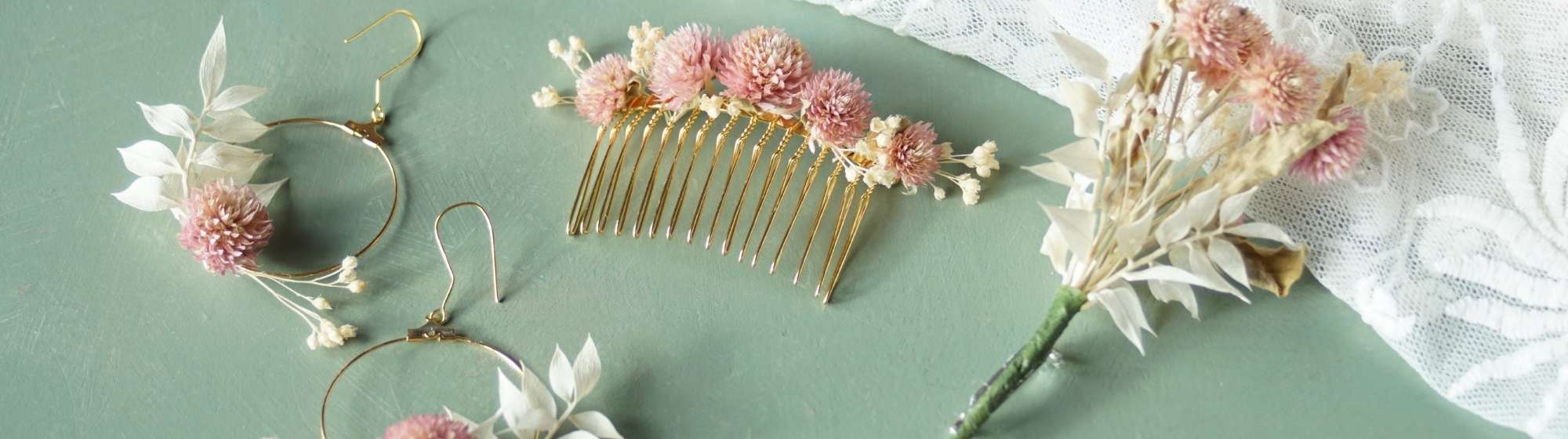 Ensemble de bijoux et accessoires en fleurs séchées, comprenant boucles d’oreilles, peigne et boutonnière, sur fond vert.