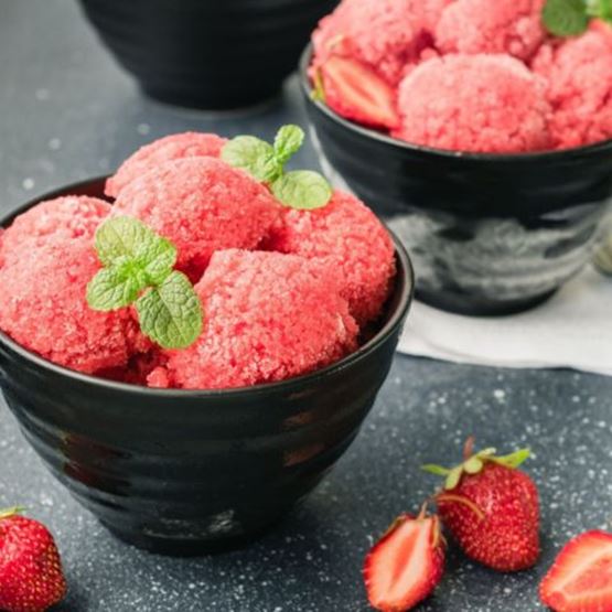 Bols de sorbet à la fraise garnis de feuilles de menthe.