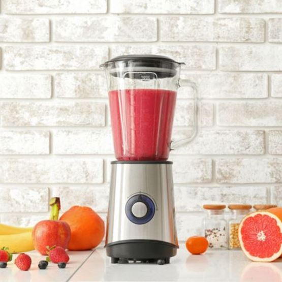 Blender contenant un smoothie rouge, entouré de fruits frais.