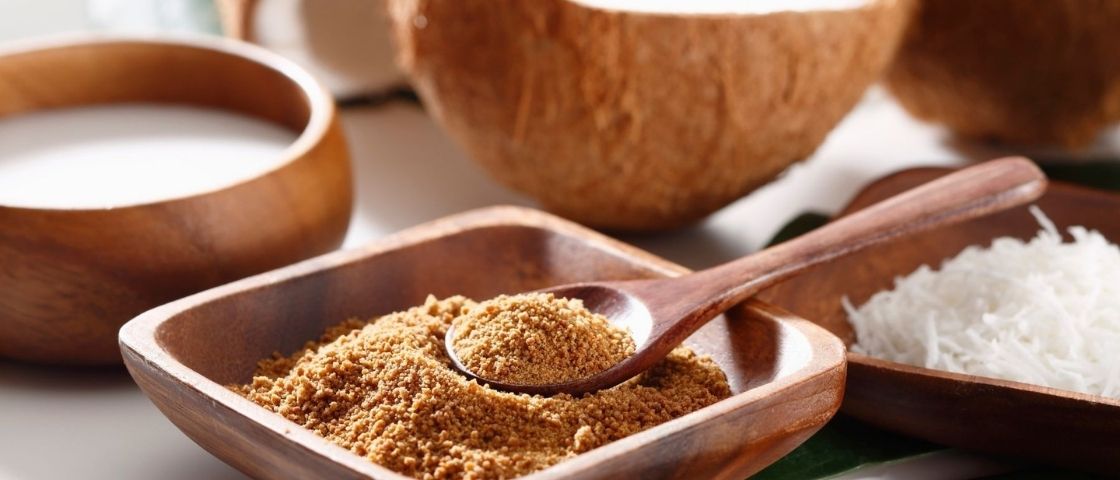 Poudre de noix de coco, lait de coco et copeaux de coco dans des bols en bois.