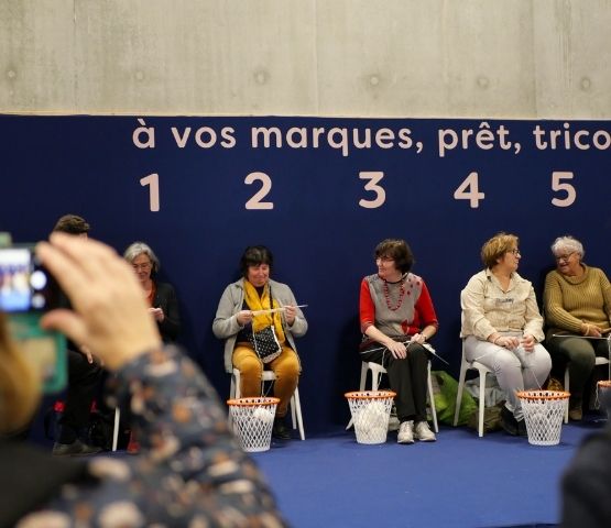 Participants tricotant côte à côte sur scène lors du concours Speed Knitting au salon Créations & Savoir-Faire.