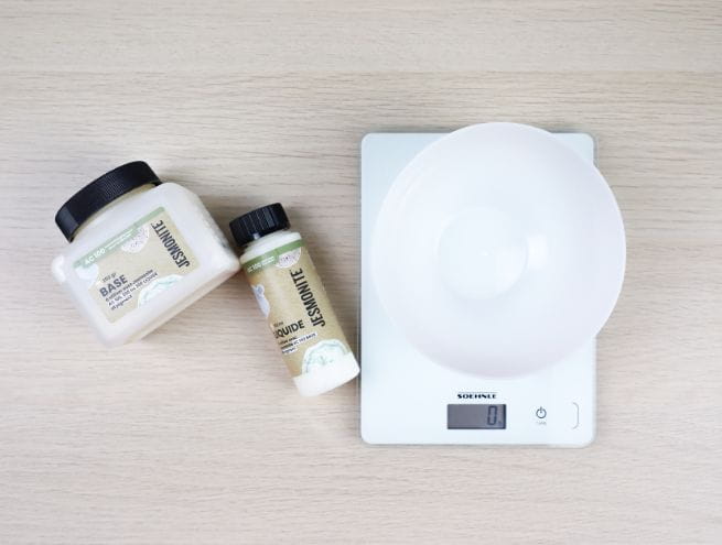 Ingrédients Jesmonite posés à côté d’une balance électronique avec bol.