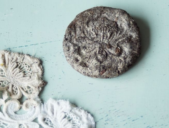 Grosse bombe à graines séchée avec une empreinte florale en dentelle.