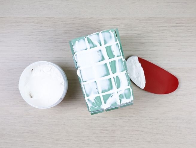 Application de l’enduit blanc entre les carreaux pour unifier la mosaïque.