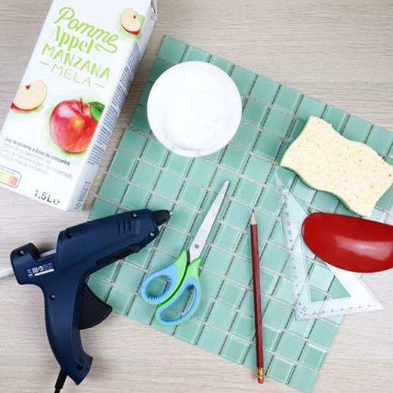 Matériel nécessaire pour fabriquer un vase mosaïque : pistolet à colle, ciseaux, carreaux, colle, crayon, éponge et brique de jus.