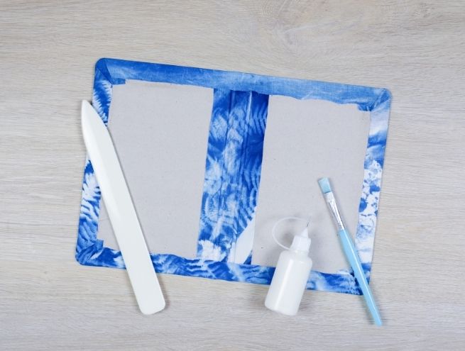 Assemblage final du carnet relié avec couverture cyanotype.